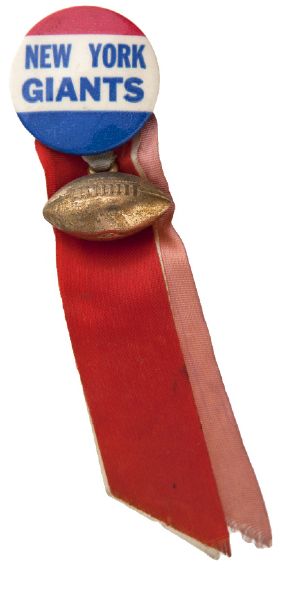 “NEW YORK GIANTS” 1950s STADIUM SOUVENIR BUTTON WITH METAL CHARM AND RIBBONS.